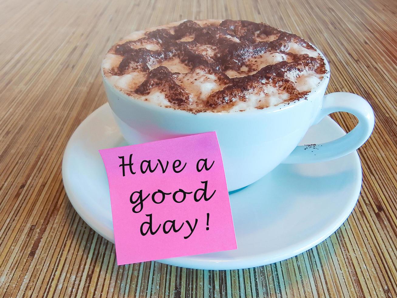 Motivational and inspirational text on a pink note on coffee cup photo