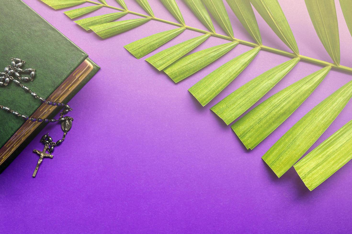 The Holy Bible, cross and palm leaves on purple background. Holy week concept. photo