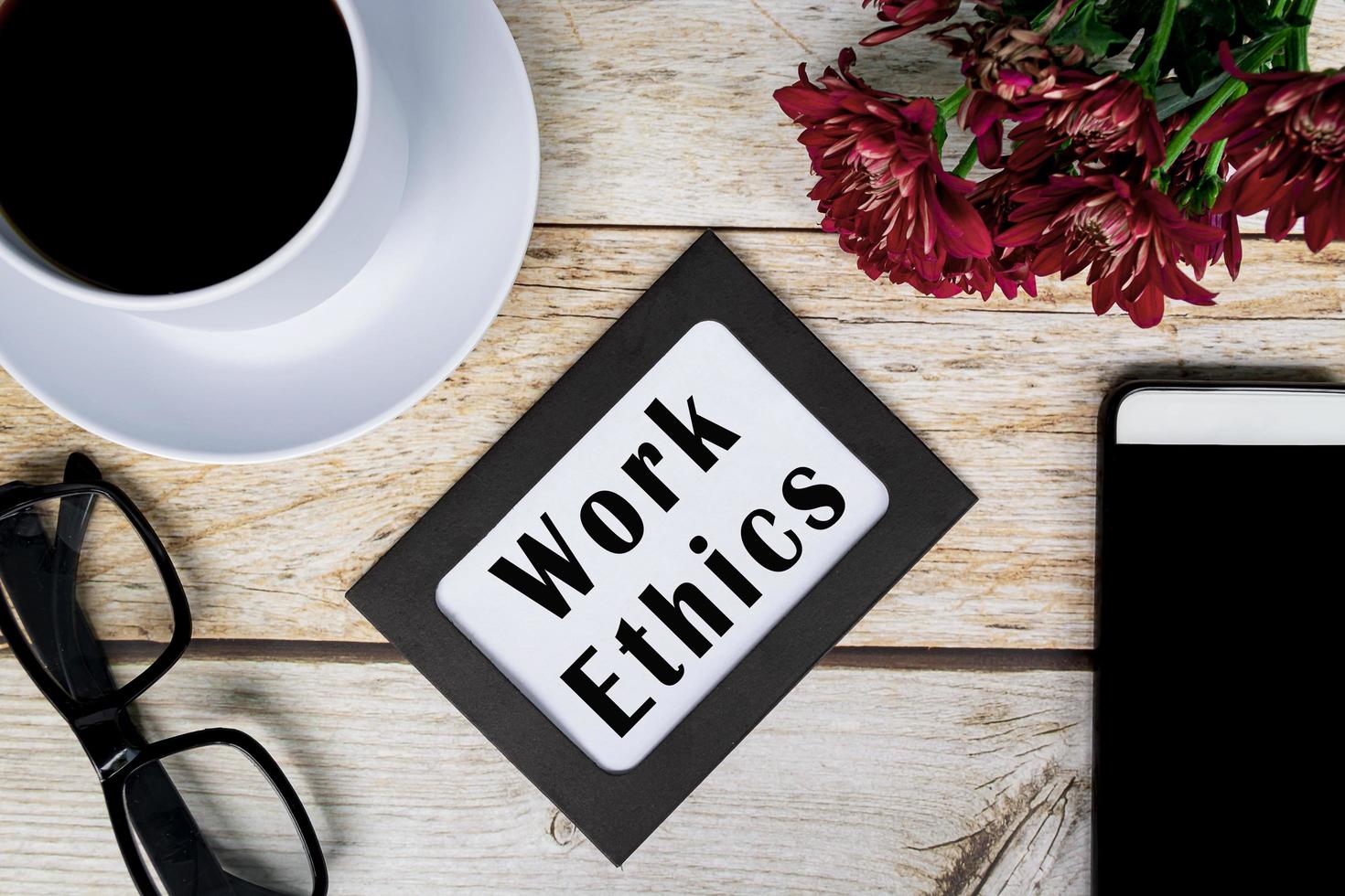 Work Ethics text on chalkboard frame on wooden desk. Business concept. photo
