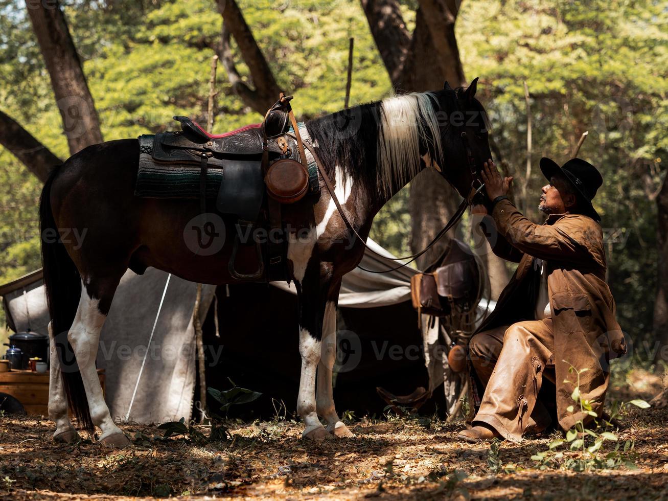 Western cowboys touch horses with love because of friendly relationships that share suffering and happiness photo