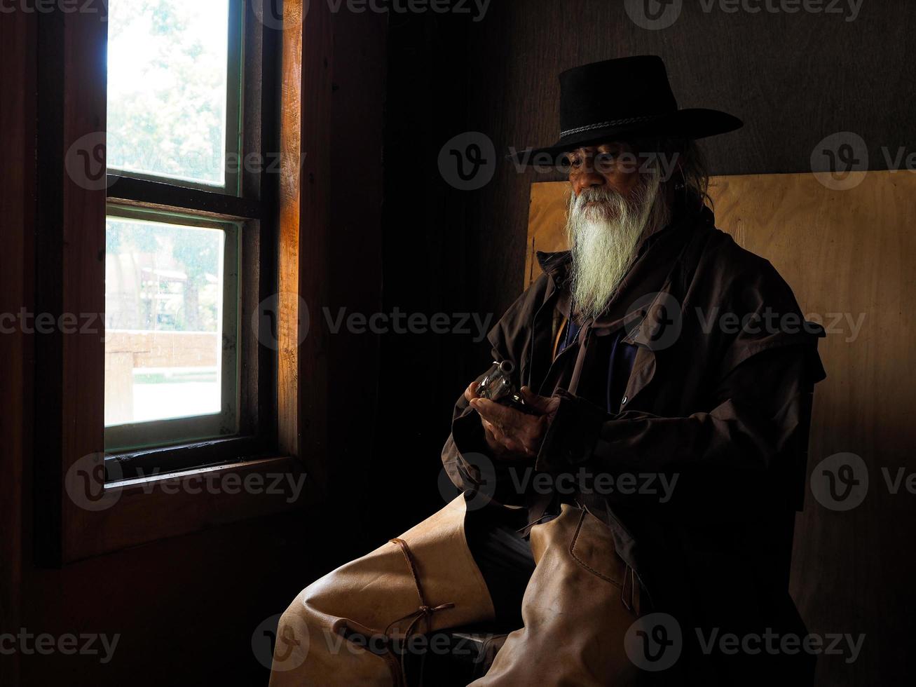 Old Western cowboy is preparing to use a gun to defend herself in a land where people must protect themselves photo