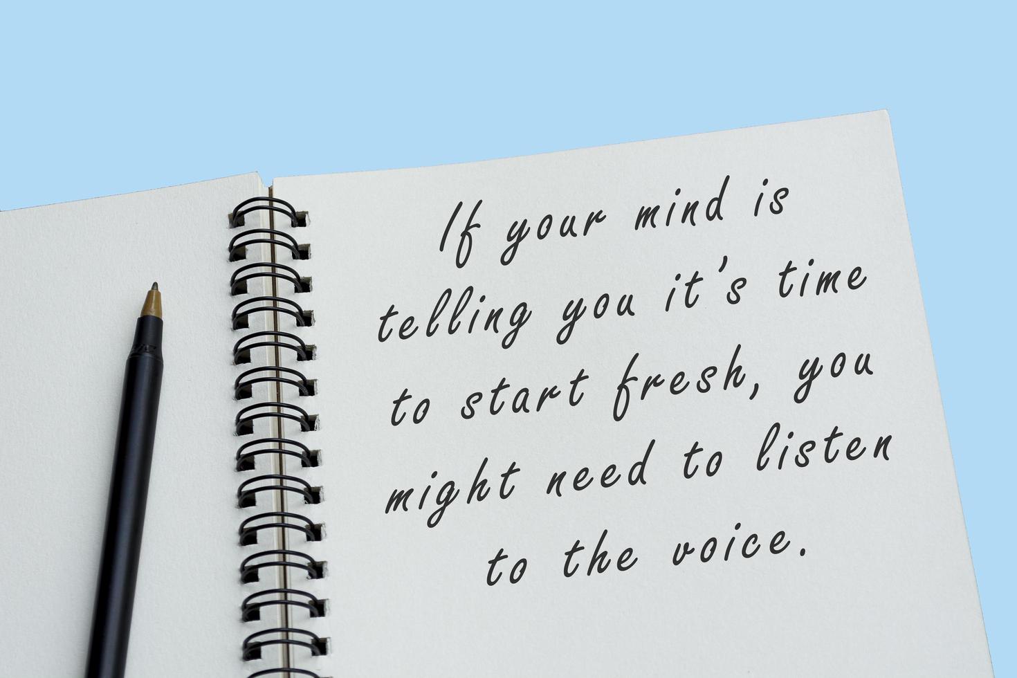 Top view of white notebook with motivational quote photo