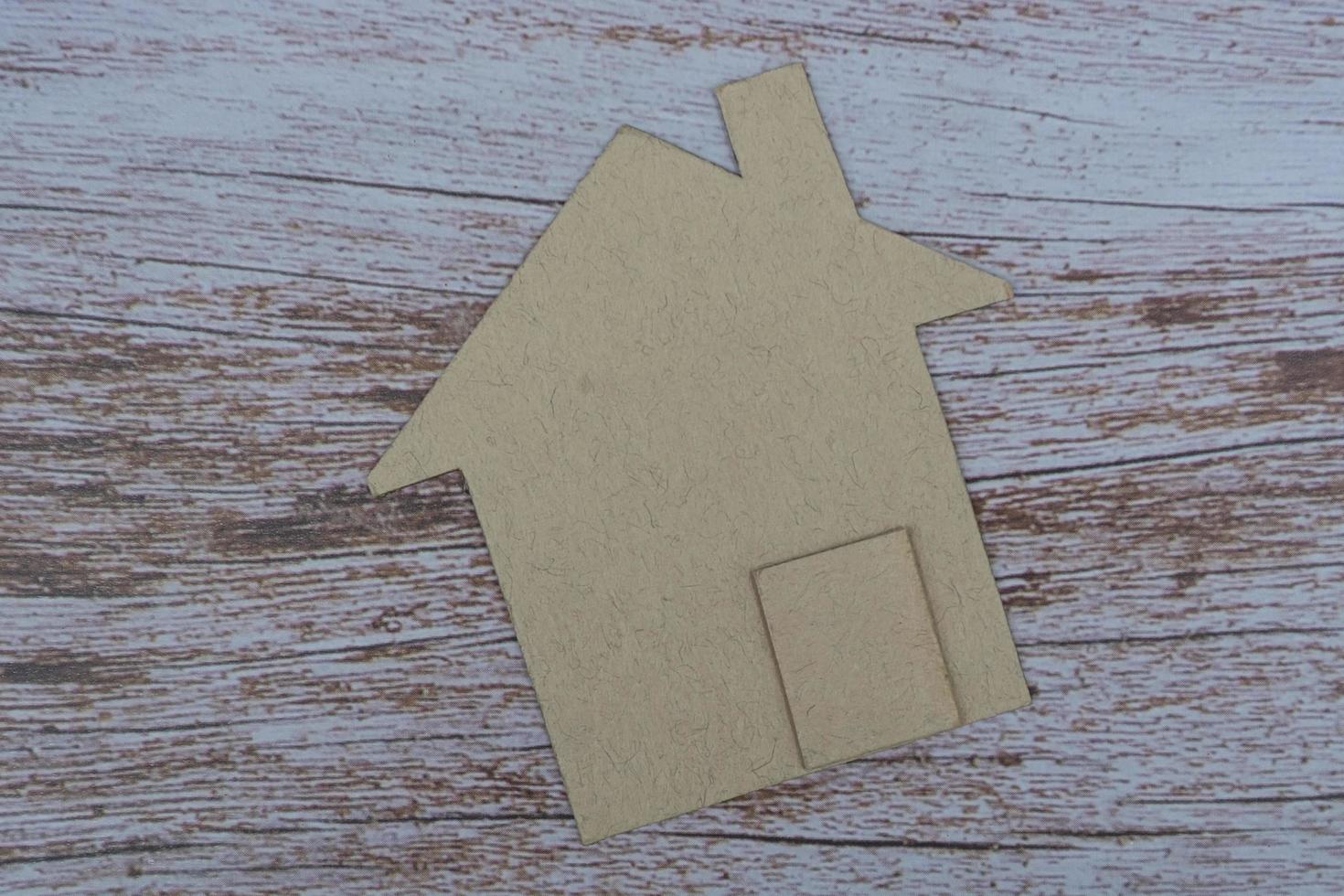 Brown paper house model on wooden table. Concept for real estate property tax photo