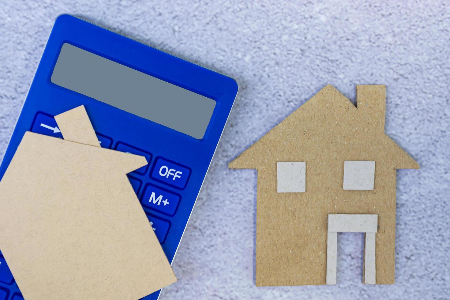 Calculator with paper house model. Home mortgage and investment concept. photo