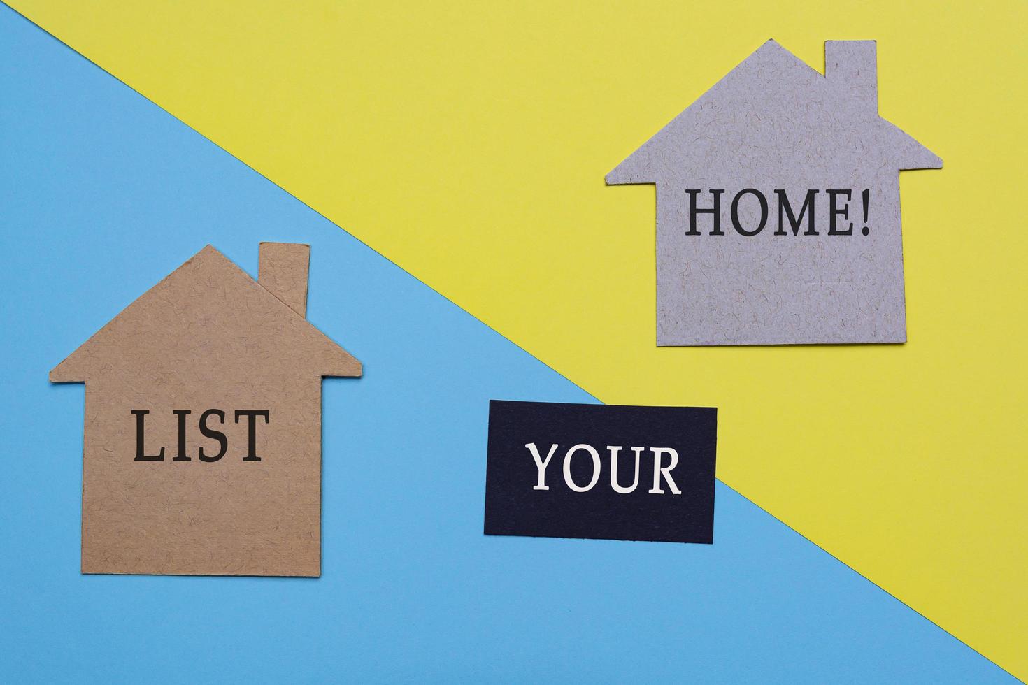 List your home text on paper house model with colored paper background photo