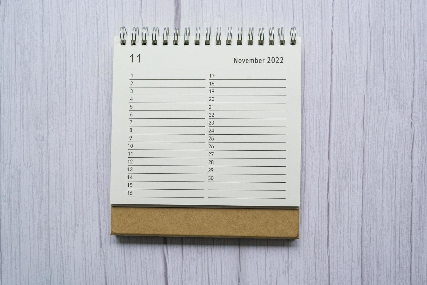 November planner and organizer 2022 calendar on wooden desk. Directly above. photo