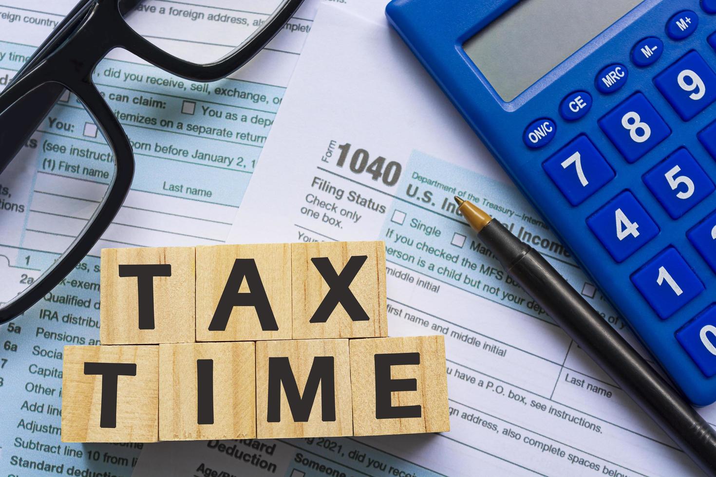 Tax time with wooden block cube with Tax forms 1040. U.S Individual Income Tax. photo