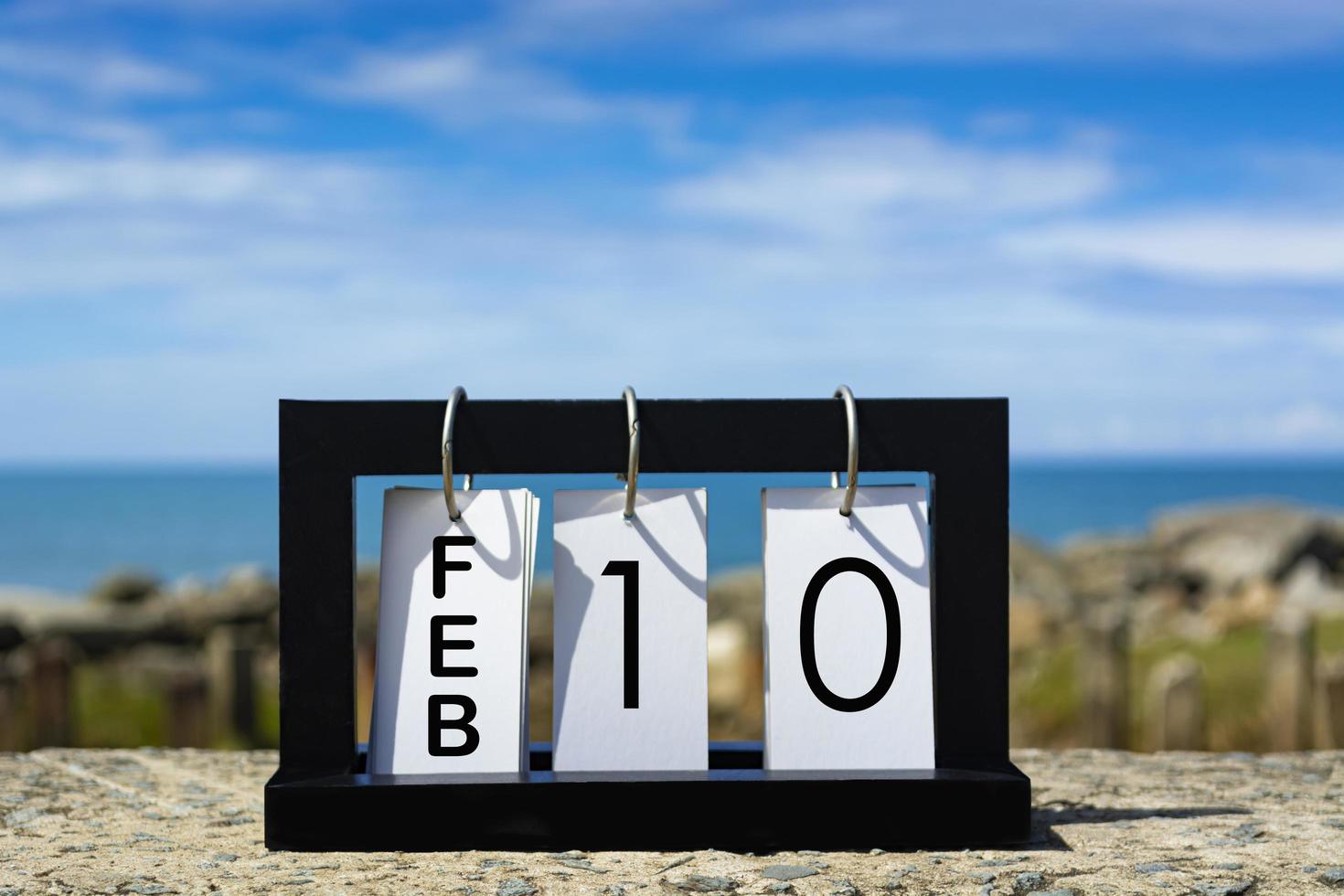 Feb 10 calendar date text on wooden frame with blurred background of ocean photo