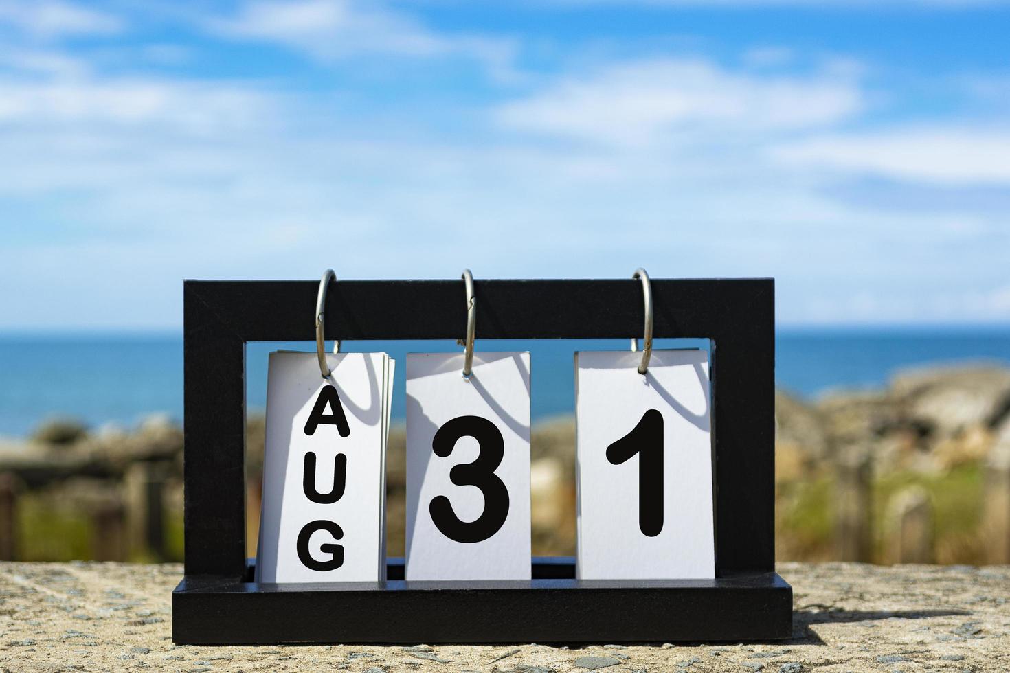 Aug 31 calendar date text on wooden frame with blurred background of ocean photo