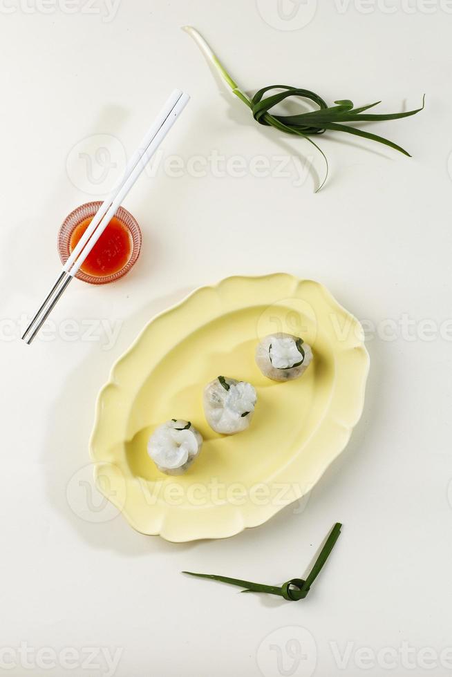 Chives Dumpling on Blue Plate and Bamboo Steamer, Copy Space for Text. Served with Red Sauce photo