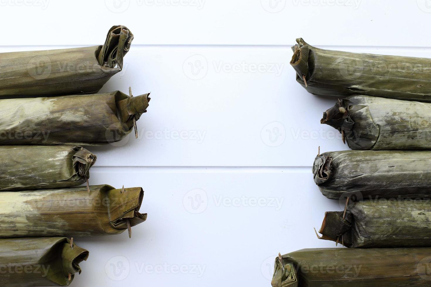 Lontong, Indonesian Compressed Rice Cake in a Form of a Cylinder Wrapped Inside a Banana Leaf. Usually Served with Sayur, Gado-Gado, or Pecel. Top View with Copy Space photo