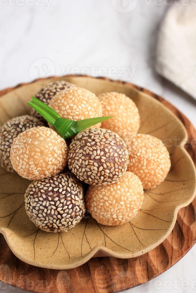 onde-onde o bola de semillas de sésamo de arroz glutinoso, servida en un plato bali de estilo tradicional indonesio. de cerca. bocadillo popular indonesio con influencia china foto