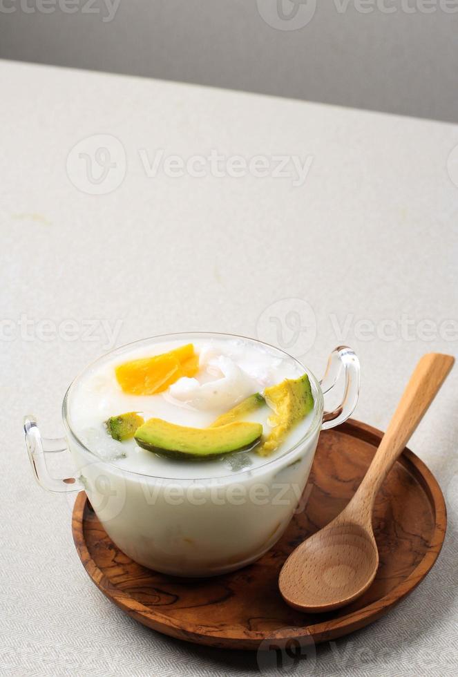 Es Teler, Traditional Indonesian Ice Dessert of Tropical Fruit Cocktail in Sweet Coconut Water and Condensed Milk. photo