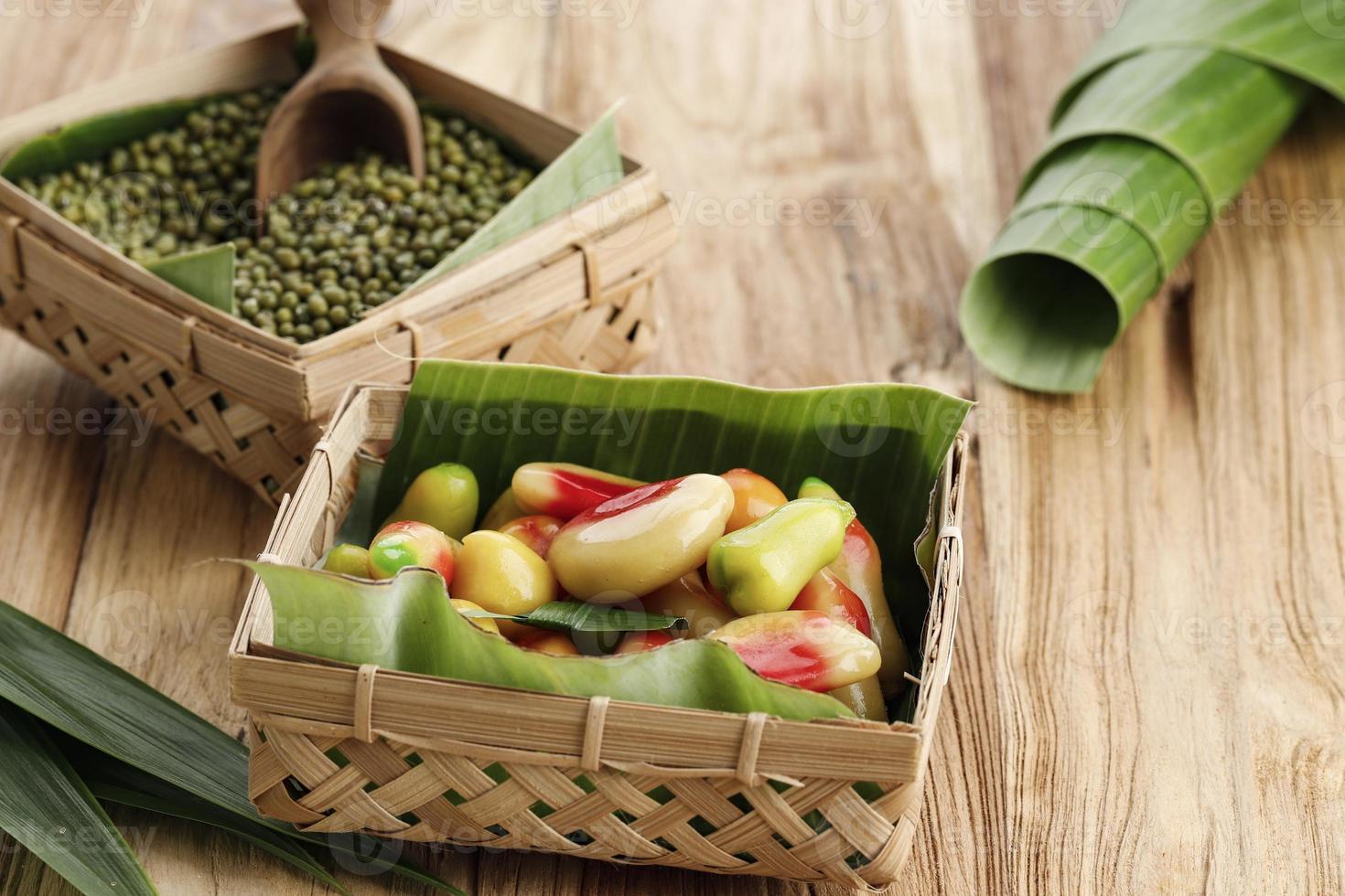 kanom look choup thai o kue ku buah indonesia, frijol mungo en forma de fruta hecho de frijol mungo y azúcar, mano manual en forma de mini fruta o verdura. foto