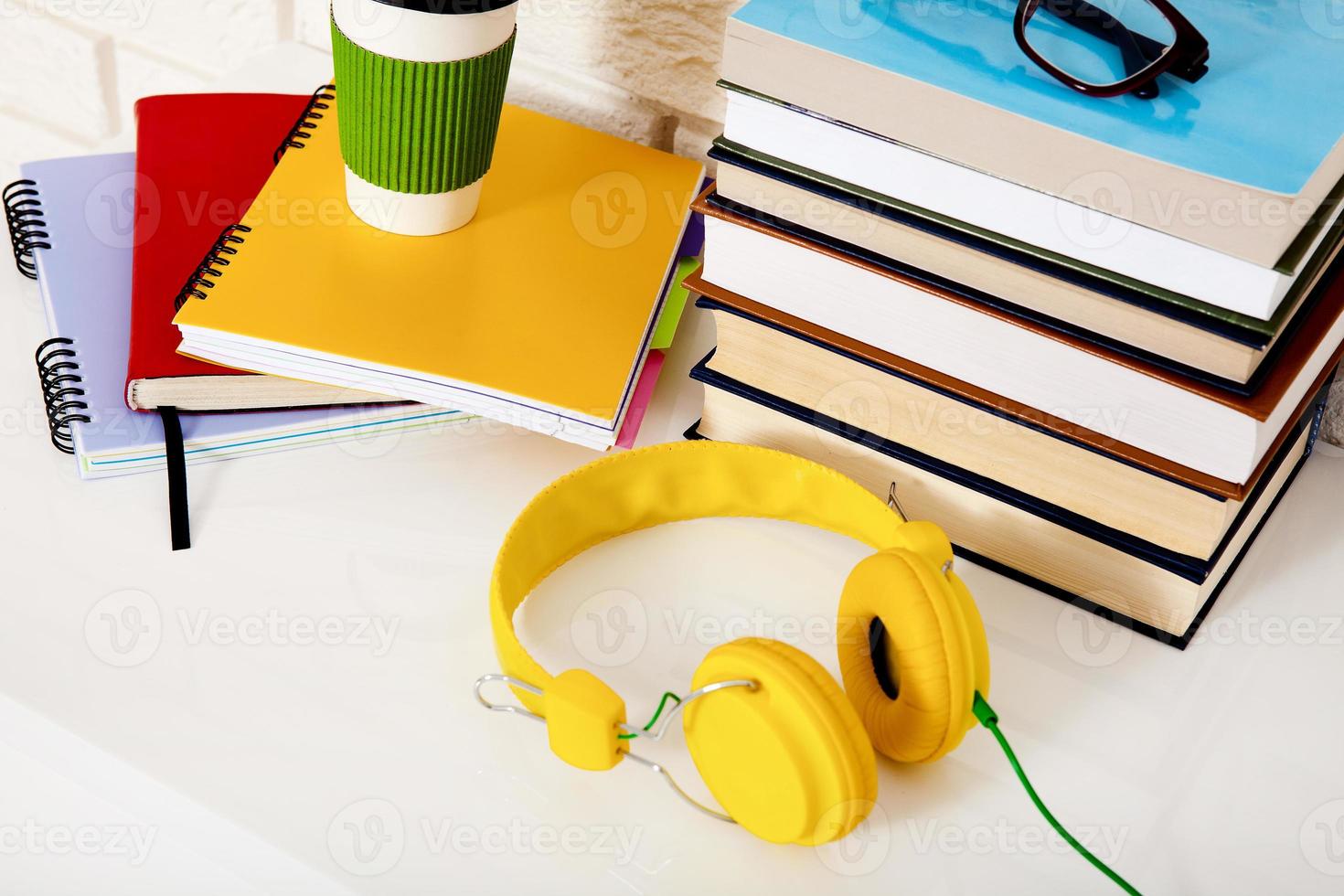 Workspace and education accessories on the table. Cup of coffee, books, glasses, notebooks, headphones. Stem education photo
