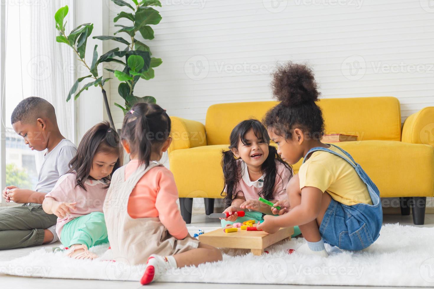 Cute little children playing toys in living room, Diverse children enjoying playing with toys photo