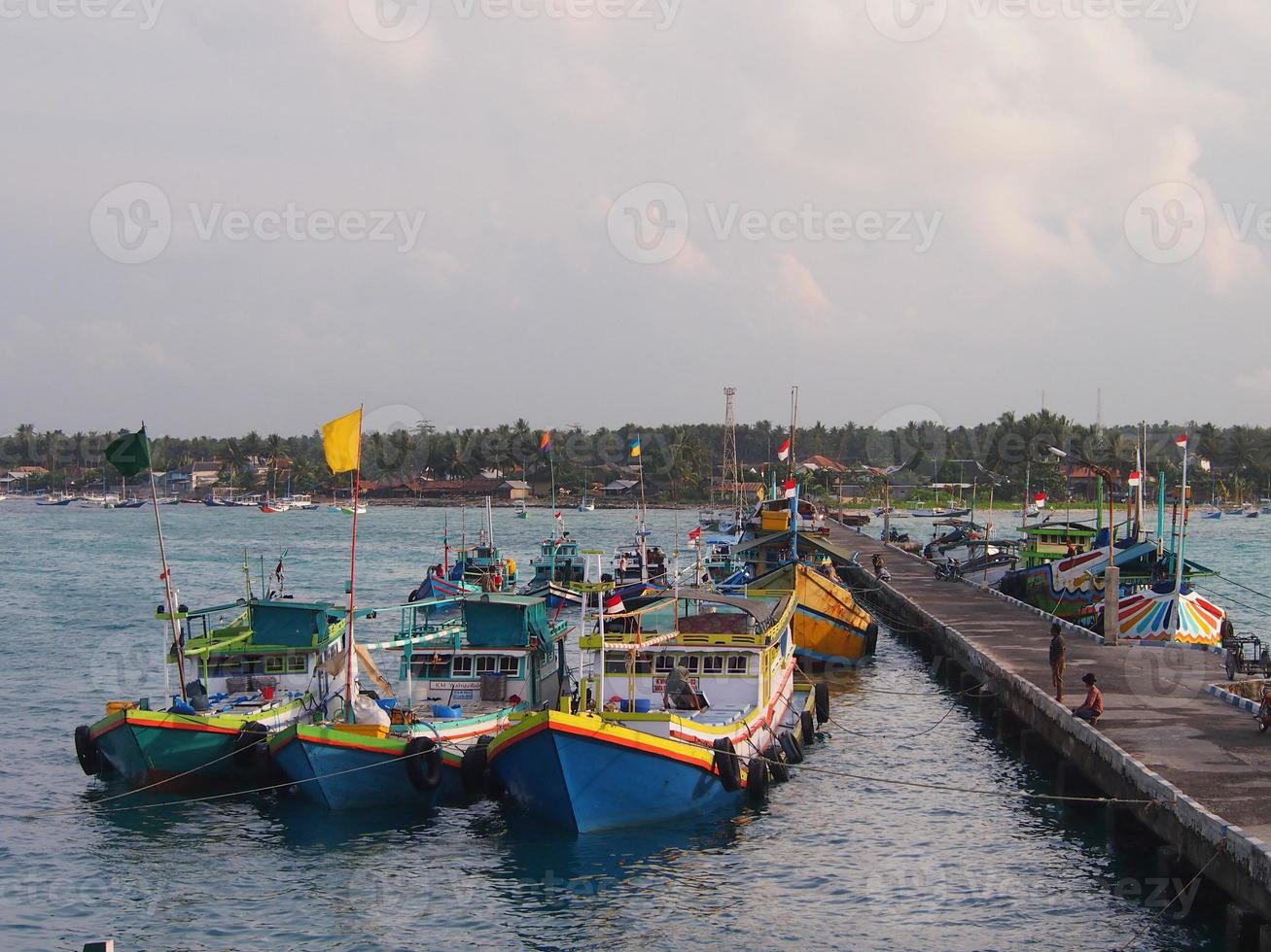 puerto tradicional por la mañana con varios barcos de pesca al lado y actividades de la gente en la isla de masalembu, indonesia. enero 2020, masalembu - indonesia foto