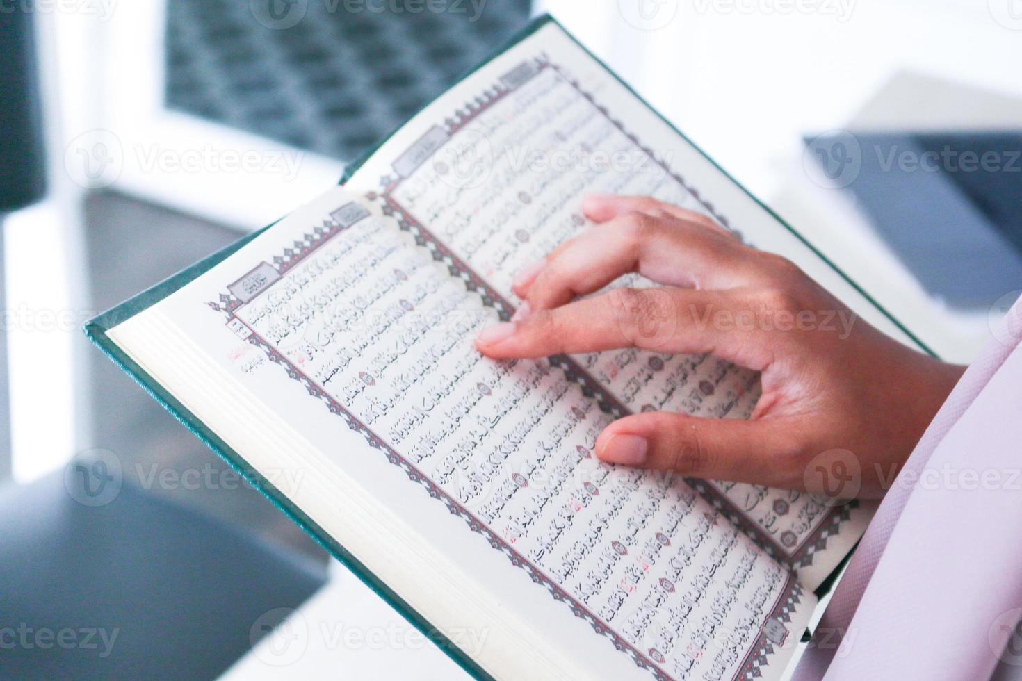 Close up of hand when reading the Holy Quran at the mosque. Selective focus photo