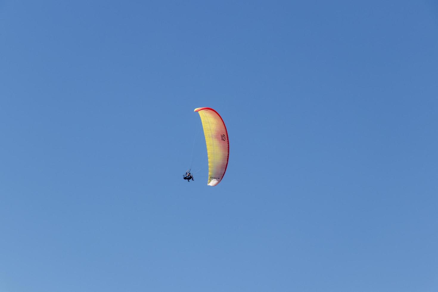 Colorful parachute aviator with blue sky. Paragliding photo