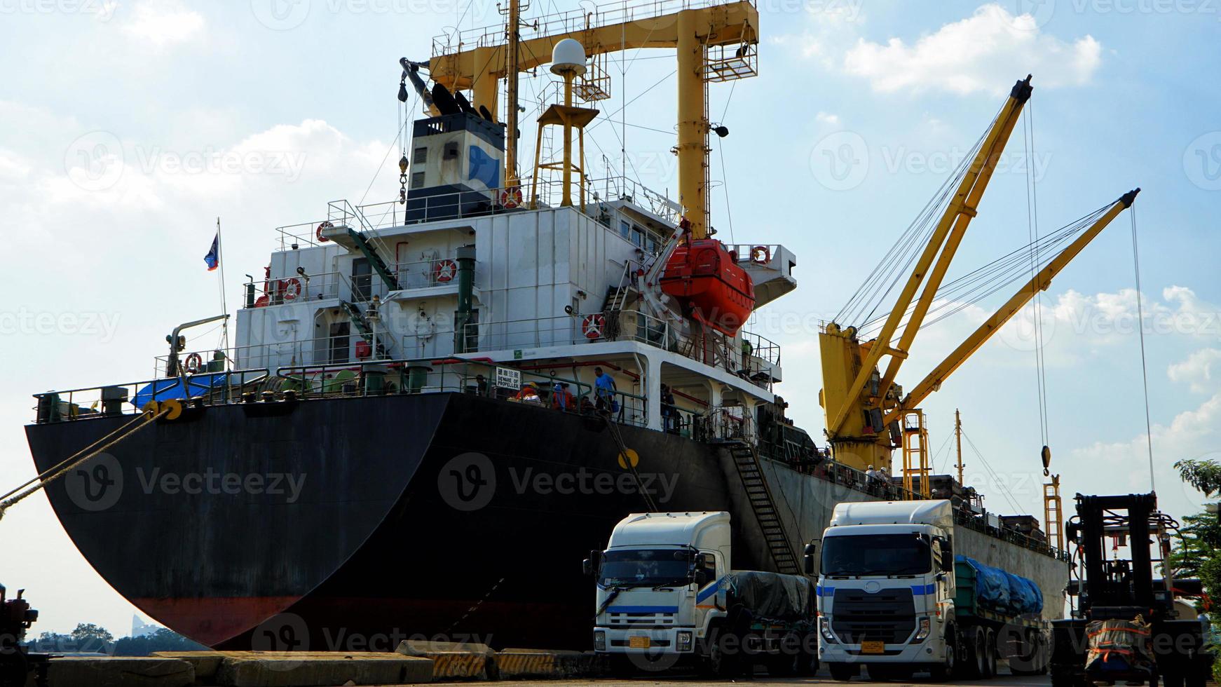 carga de contenedores en un buque de carga con grúa industrial. buque portacontenedores en empresa de logística comercial de importación y exportación. concepto de industria y transporte. foto