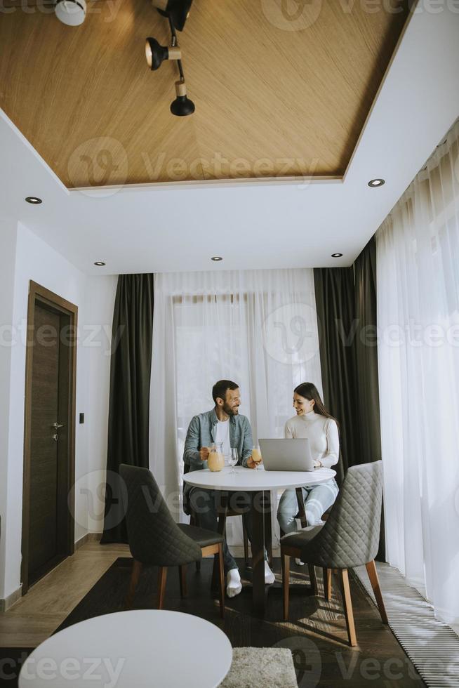 Young couple using laptop computer on the table in the living room photo