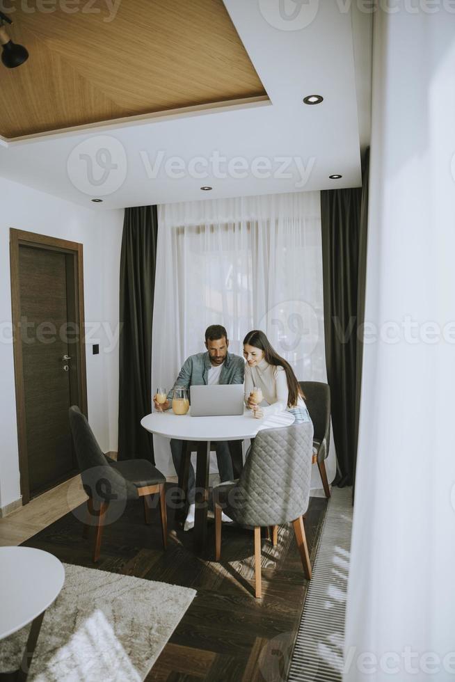 Young couple using laptop computer on the table in the living room photo