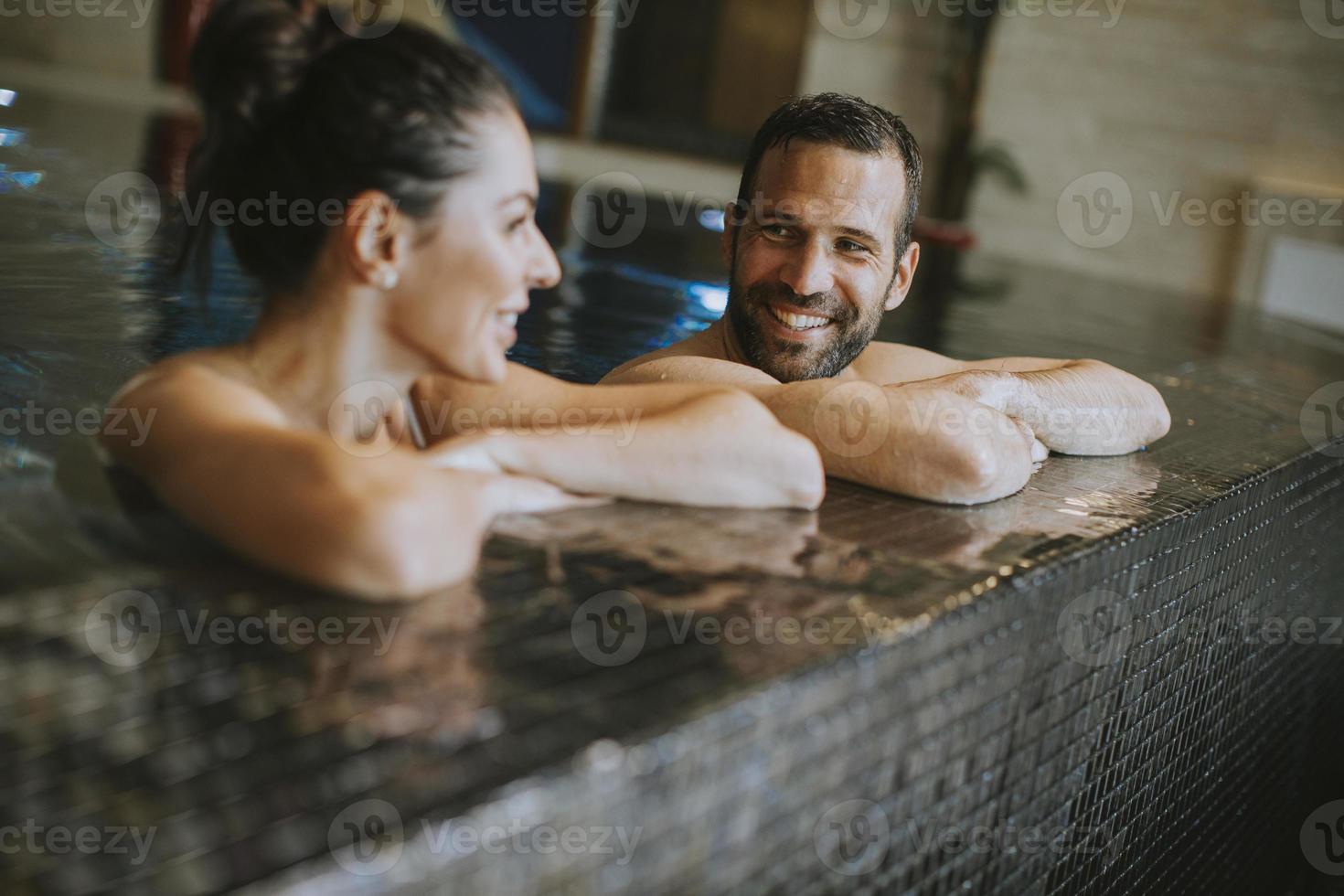 Young couple relaxing in a swimming pool photo
