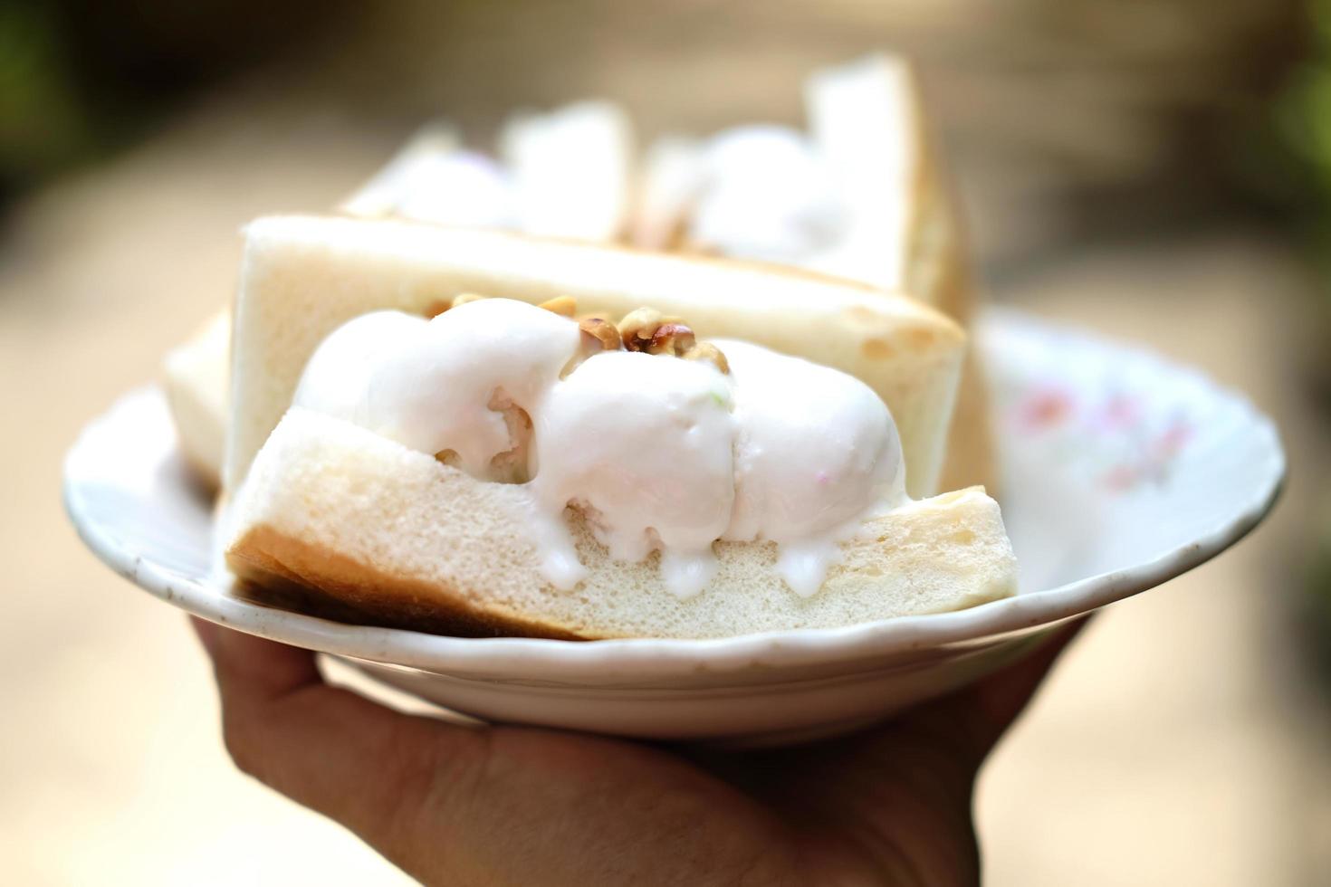 Hand holding Coconut ice cream with bread photo