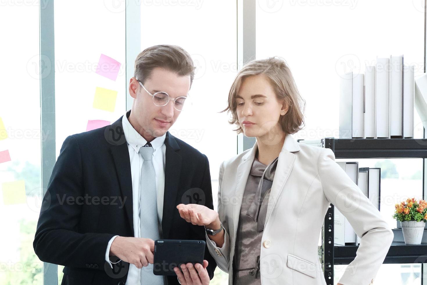Successful businessman and businesswoman meeting and hand holding laptop for good ideas in modern office photo