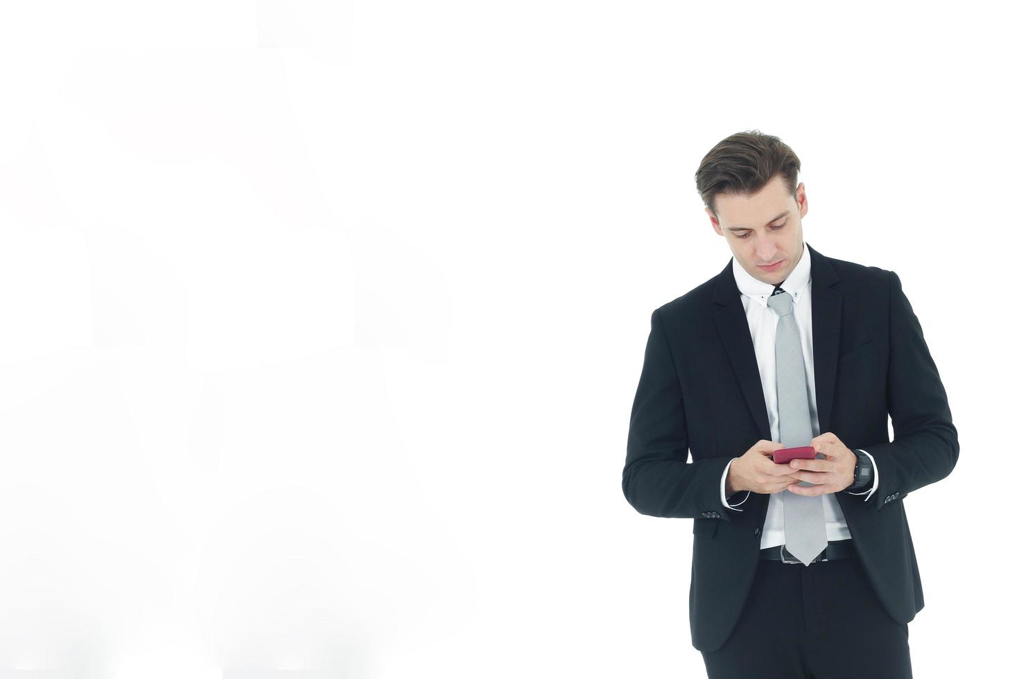 Handsome businessman in a suit hand holding smartphone isolated on white background.Copy Space photo