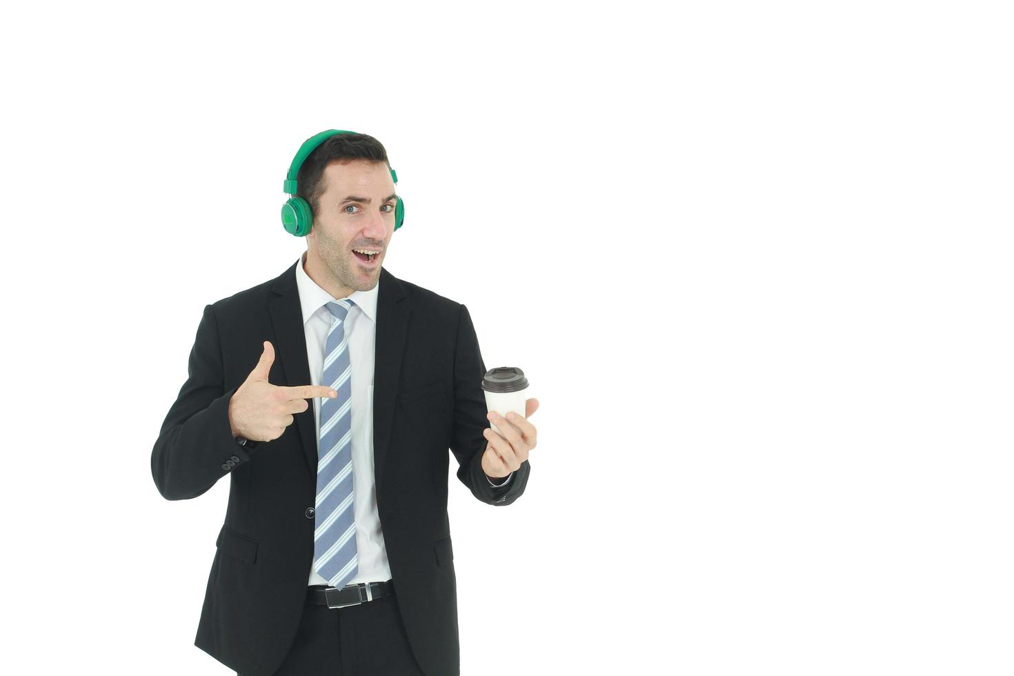 un hombre de negocios apuesto e inteligente se relaja escuchando música con auriculares verdes y sosteniendo una taza de café aislada de fondo blanco. concepto de negocios y finanzas. copie el espacio foto