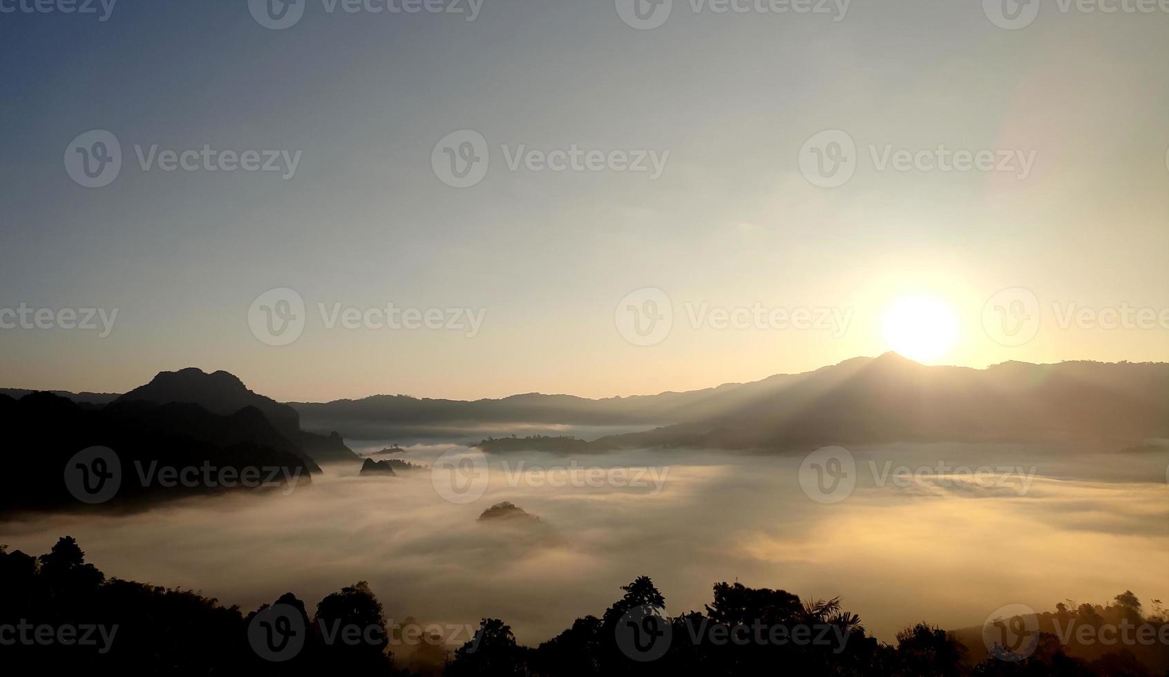 The sunrise and the mountain cover with the fog photo