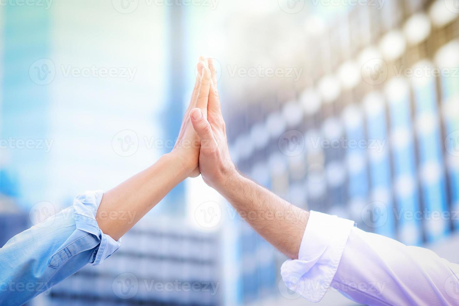Cloe up of both hands giving high five to each other With a blurred building background, in the concept of successful business collaboration and teamwork photo