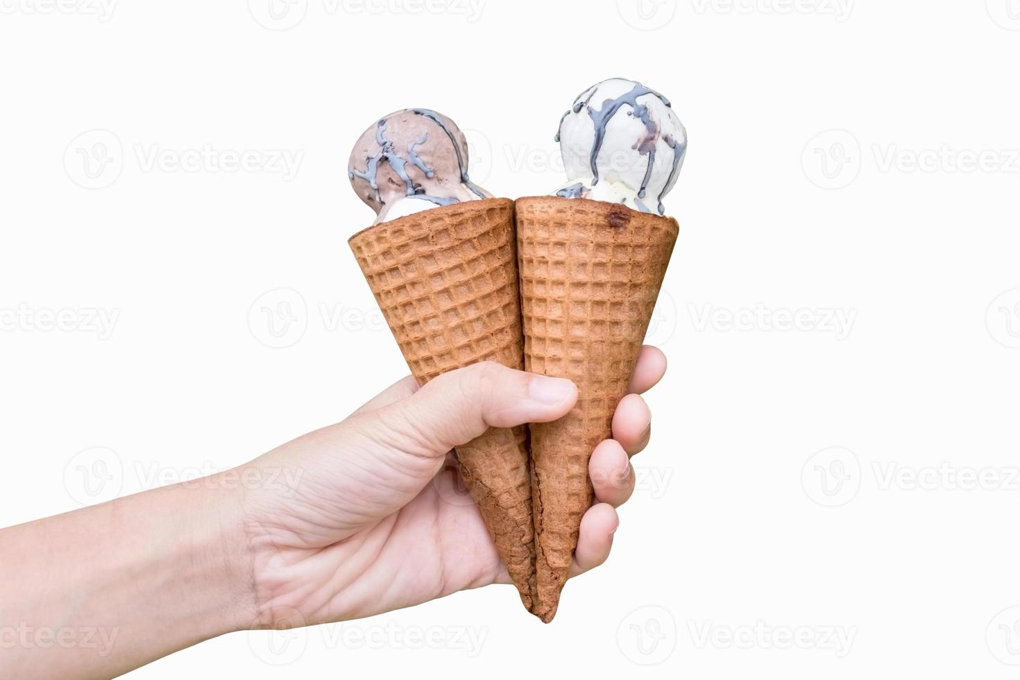 Kid 's hand holding two ice cream cone scoop chocolate and vanilla flavour isolated on white background with copy space.Clipping path included.Concept sharing and celebration. photo