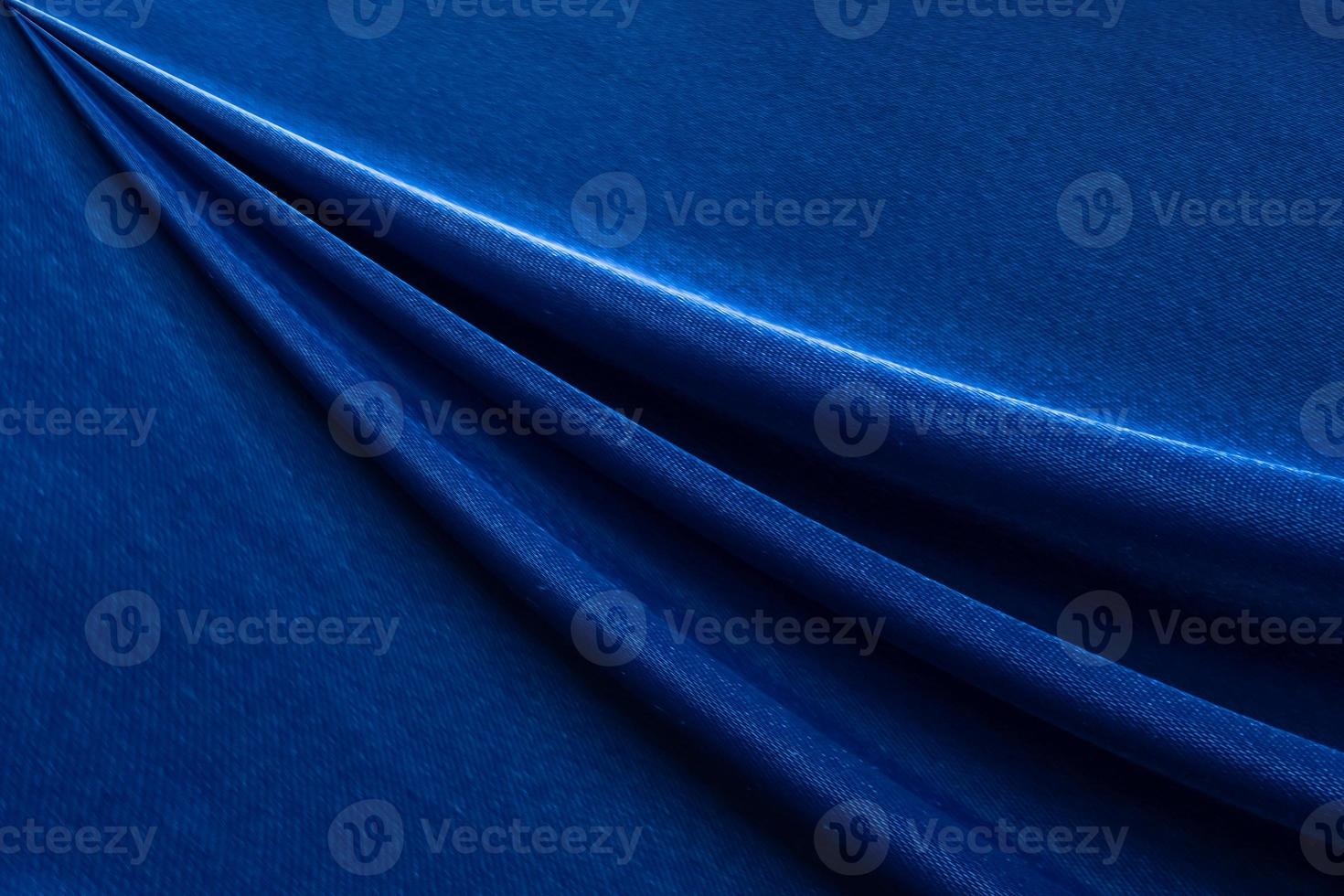 Luxury deep blue fabric background.Smooth wavy fold pattern.Elegant curve.Silk velvet material texture.Using for backdrop or wallpaper.Dark tone color. photo