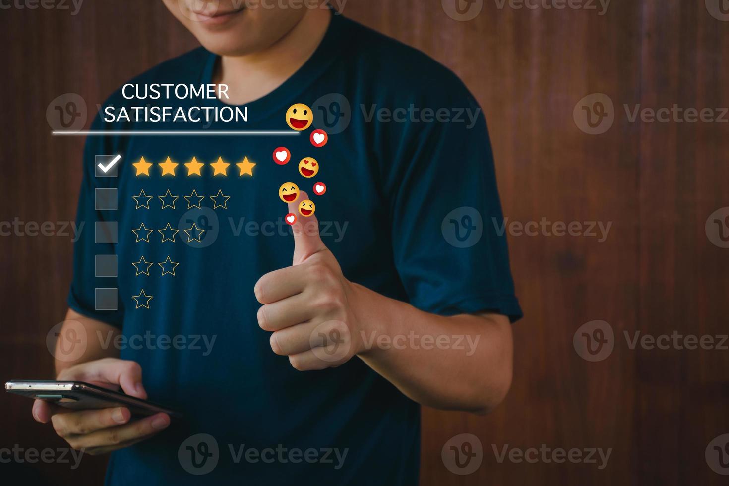 Customer satisfaction assessment concept, man using smartphone smiling and thumbs up, rate five stars, send smiley emoji and hearts, satisfied smiley face, excellent service, customer be happy. photo