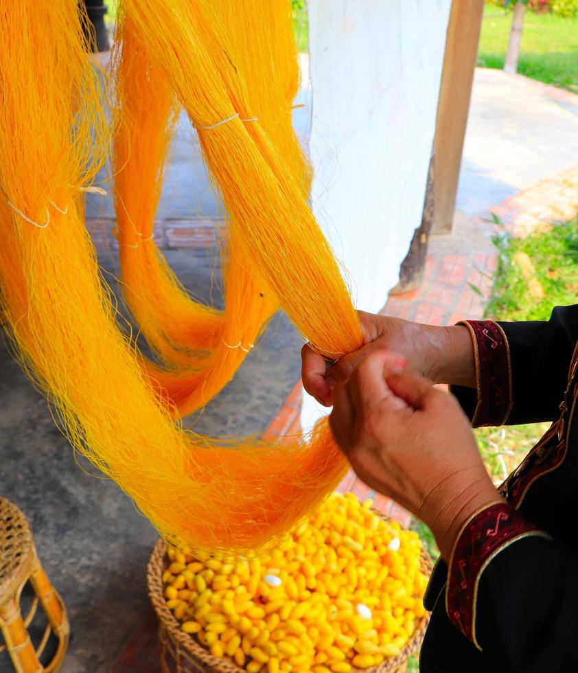 Senior woman is drying silk yarns photo