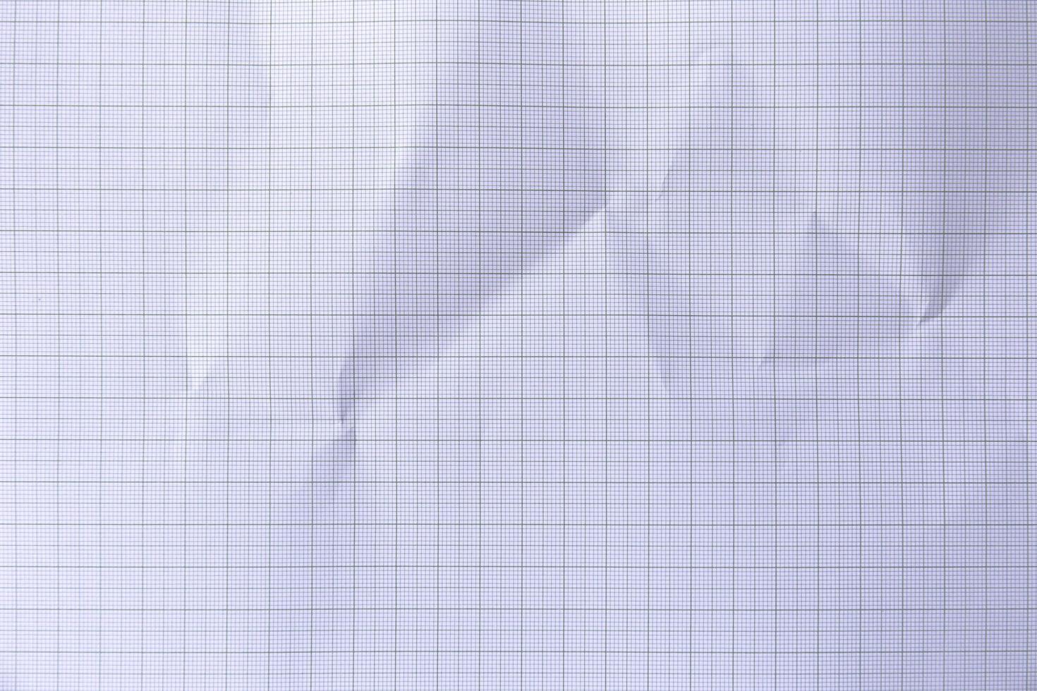 Square crumpled square graph paper on the background. photo