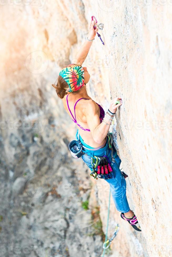 Climber while inserting rope carabiner photo