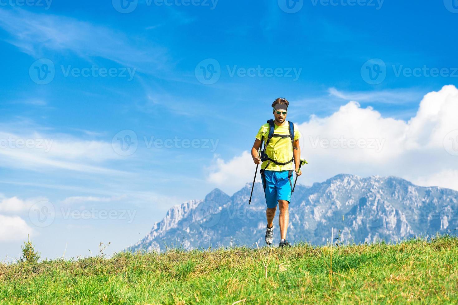 Young man practicing physical activity mountain and running with sticks photo