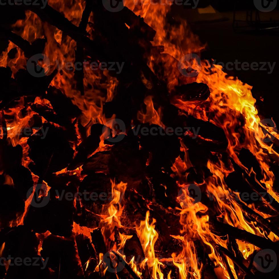 llamas de fuego sobre fondo negro, fondo de textura de llama de fuego blaze, maravillosamente, el fuego está ardiendo, llamas de fuego con madera y hoguera de estiércol de vaca foto