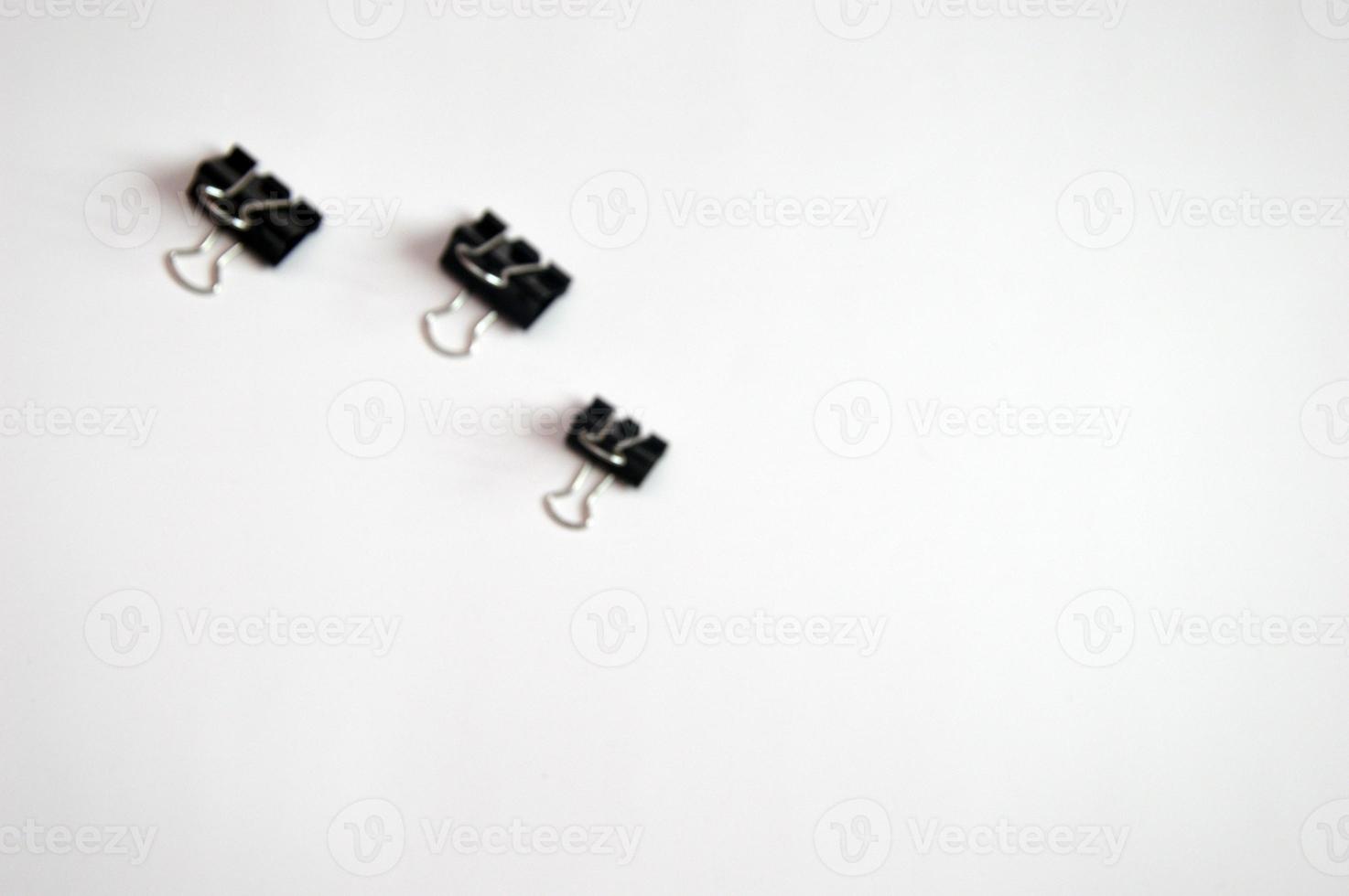 Black paper clips, paper document clips accessories, stationery isolated on background. Free space for text. photo