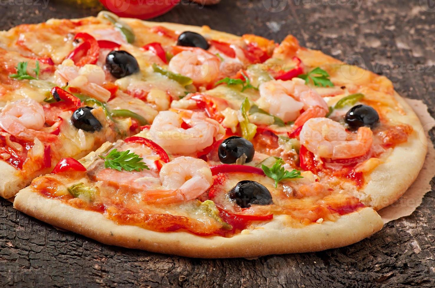 pizza con camarones, salmón y aceitunas foto