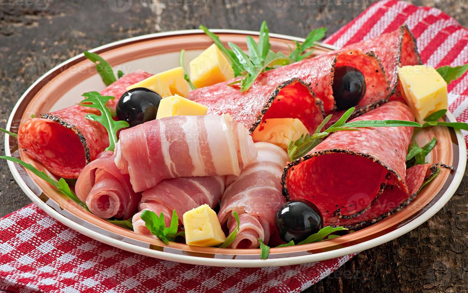 Meat appetizer on a plate on old wooden background photo