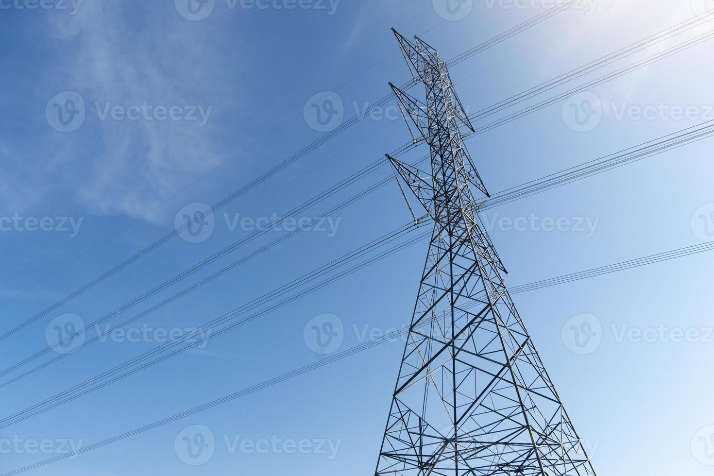 High-voltage poles on steel structures run through cables. Under the blue sky. photo