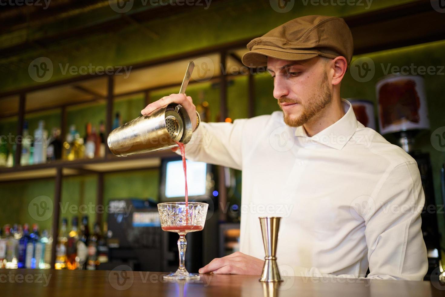 barman sirviendo un cóctel en un vaso en un pub moderno foto