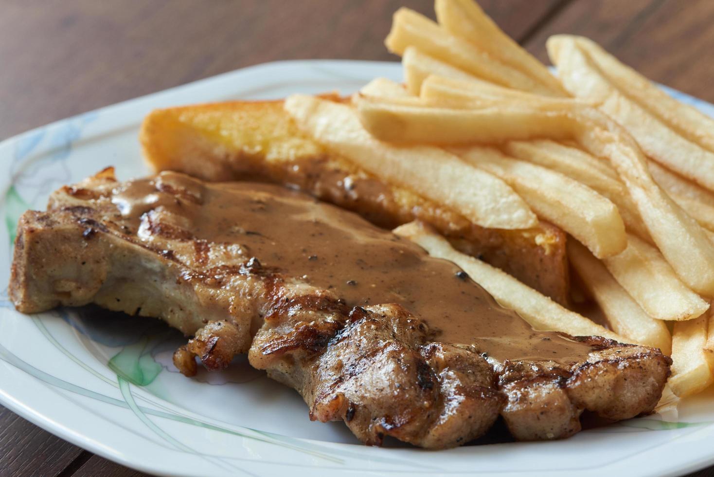 Close-up view of delicious porkchop, french fries and butter photo