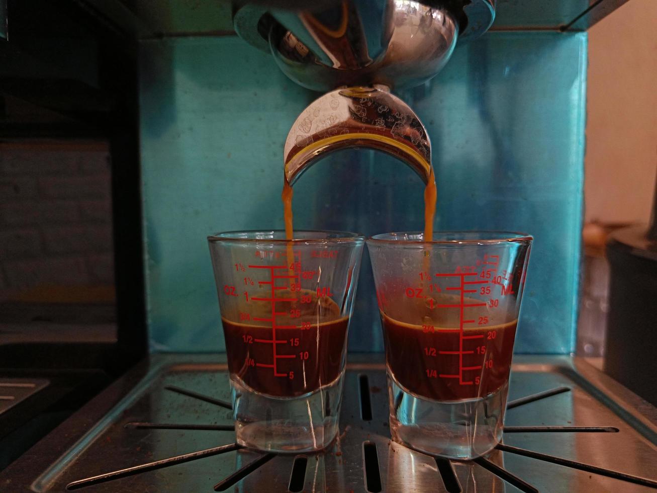 café recién hecho goteando en una taza de una cafetera profesional foto