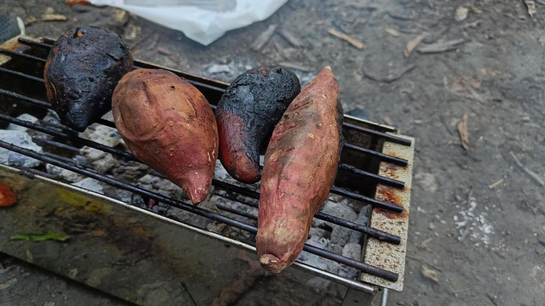 Roasted sweet potatoes on the charcoal grill There are both scorched and normal versions. photo