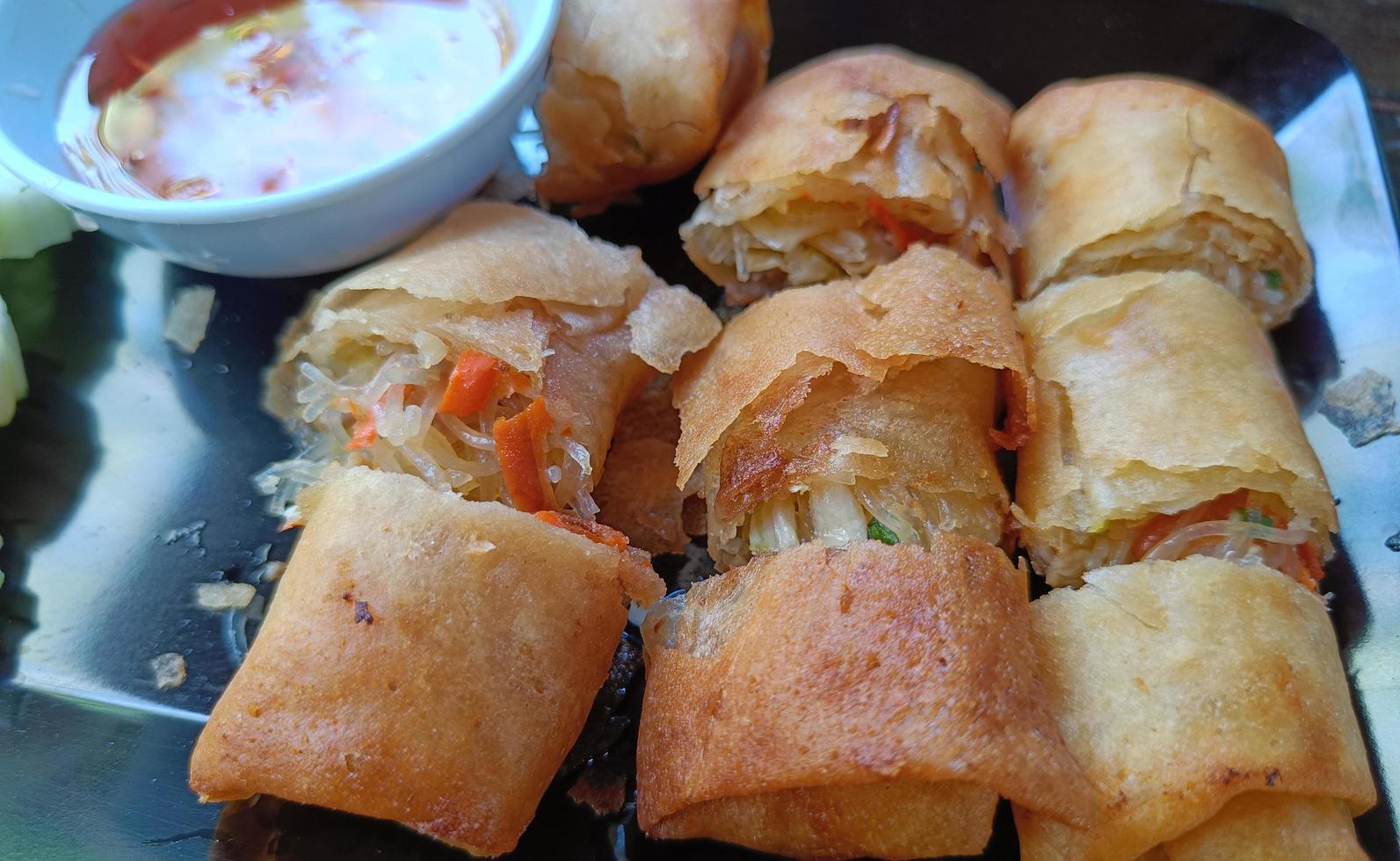 deep fried spring rolls sliced on black plate photo